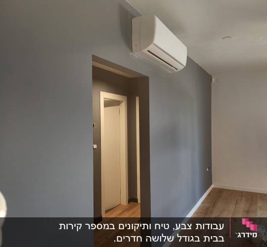 קיר צבוע באפור עם פחית צבע על הרצפה